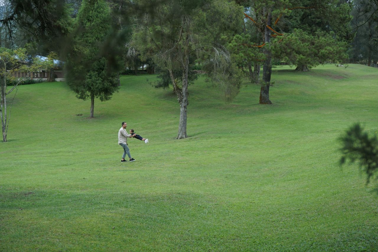 Keluarga bersantai di halaman rumput hotel